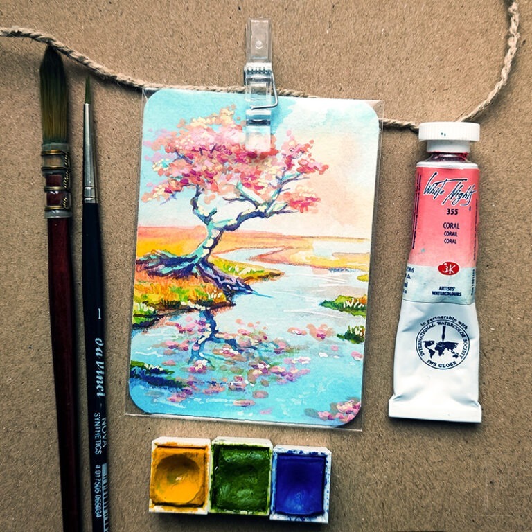 rosa blühender Baum mit einem gewundenen Stamm, der am Rande eines ruhigen Gewässers wächst. Der Baum und die umgebende Landschaft spiegeln sich im Wasser. Der Himmel weist sanfte Pfirsich- und Blautöne auf.